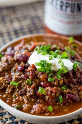 chili slow cooker beef with sour cream and chibe in white boawl